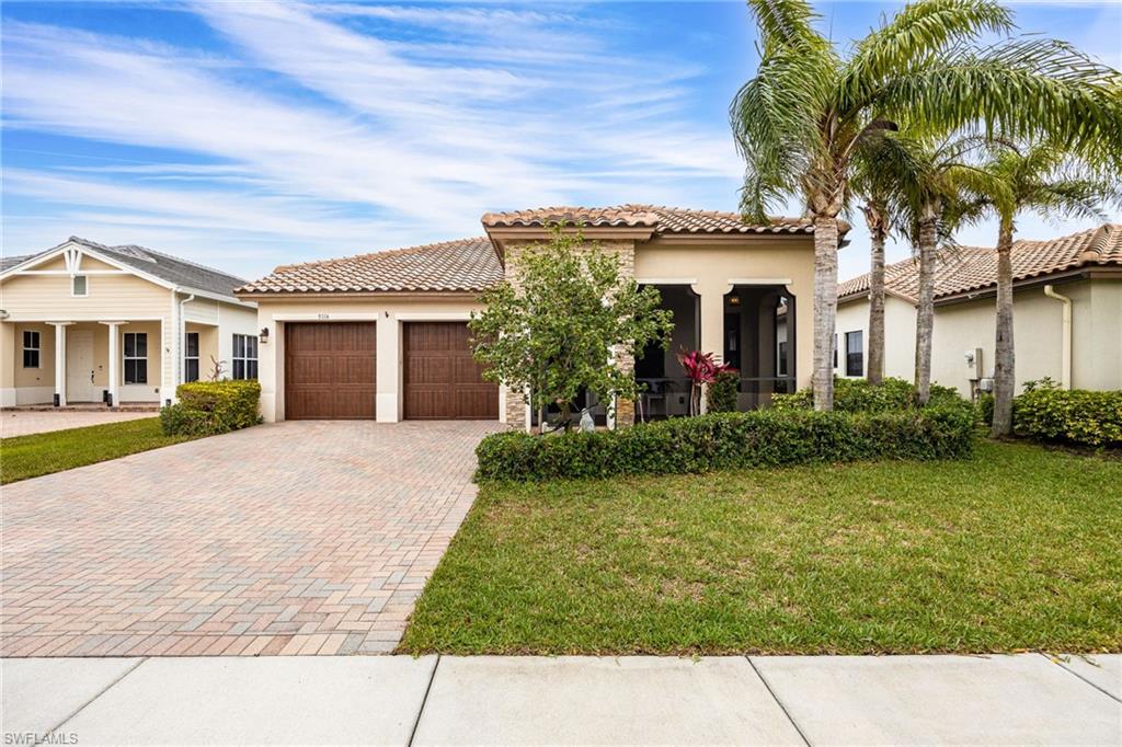 5116 Salerno Street Ave Maria, FL 34142 - Photo 1 of 36 a front view of a house with a garden