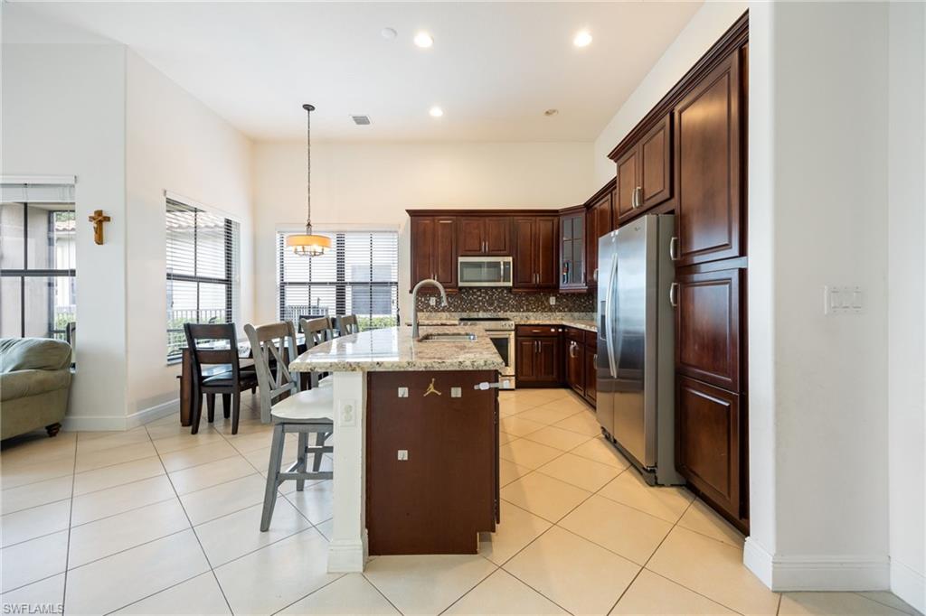 5116 Salerno Street Ave Maria, FL 34142 - Photo 14 of 36 a kitchen with stainless steel appliances granite countertop a refrigerator and a stove