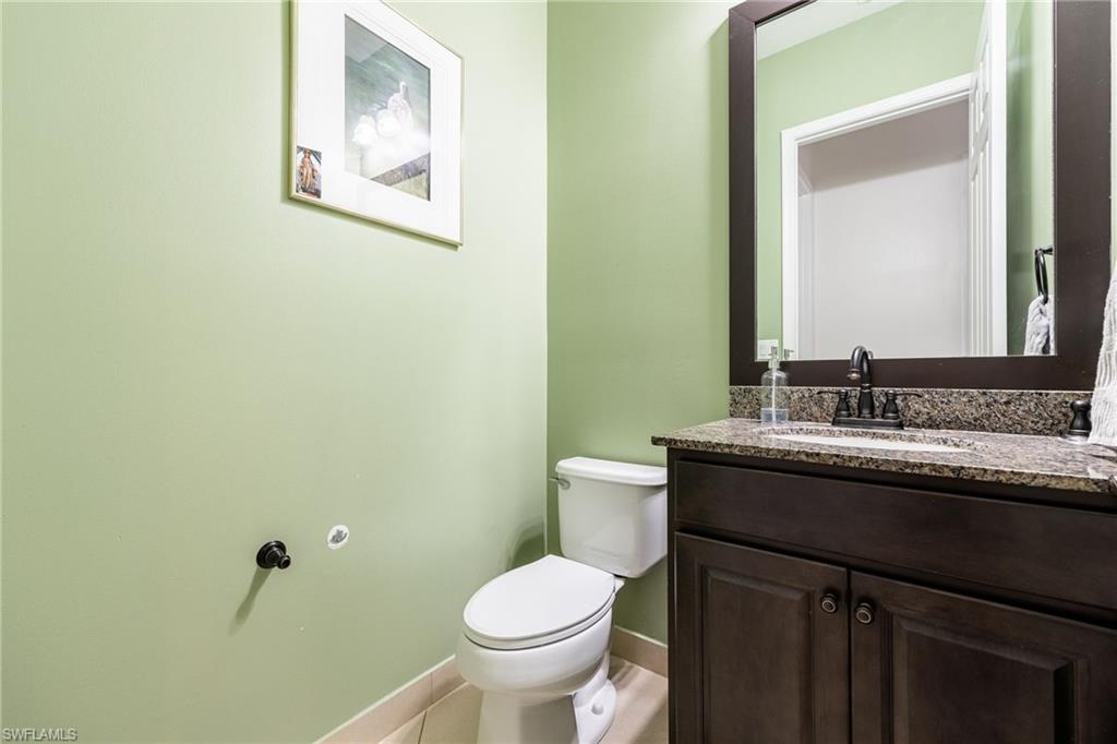 5116 Salerno Street Ave Maria, FL 34142 - Photo 24 of 36 a bathroom with a granite countertop toilet sink and mirror