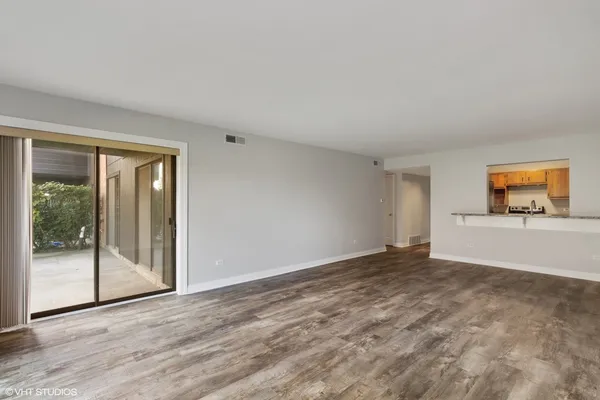 a view of a livingroom with wooden floor and a flat screen tv