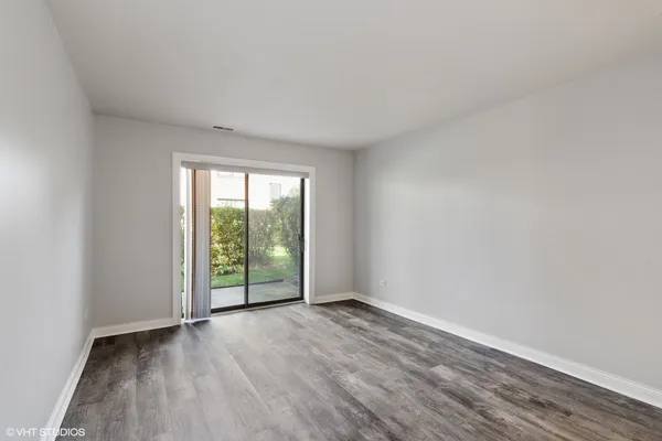 an empty room with wooden floor and sliding door