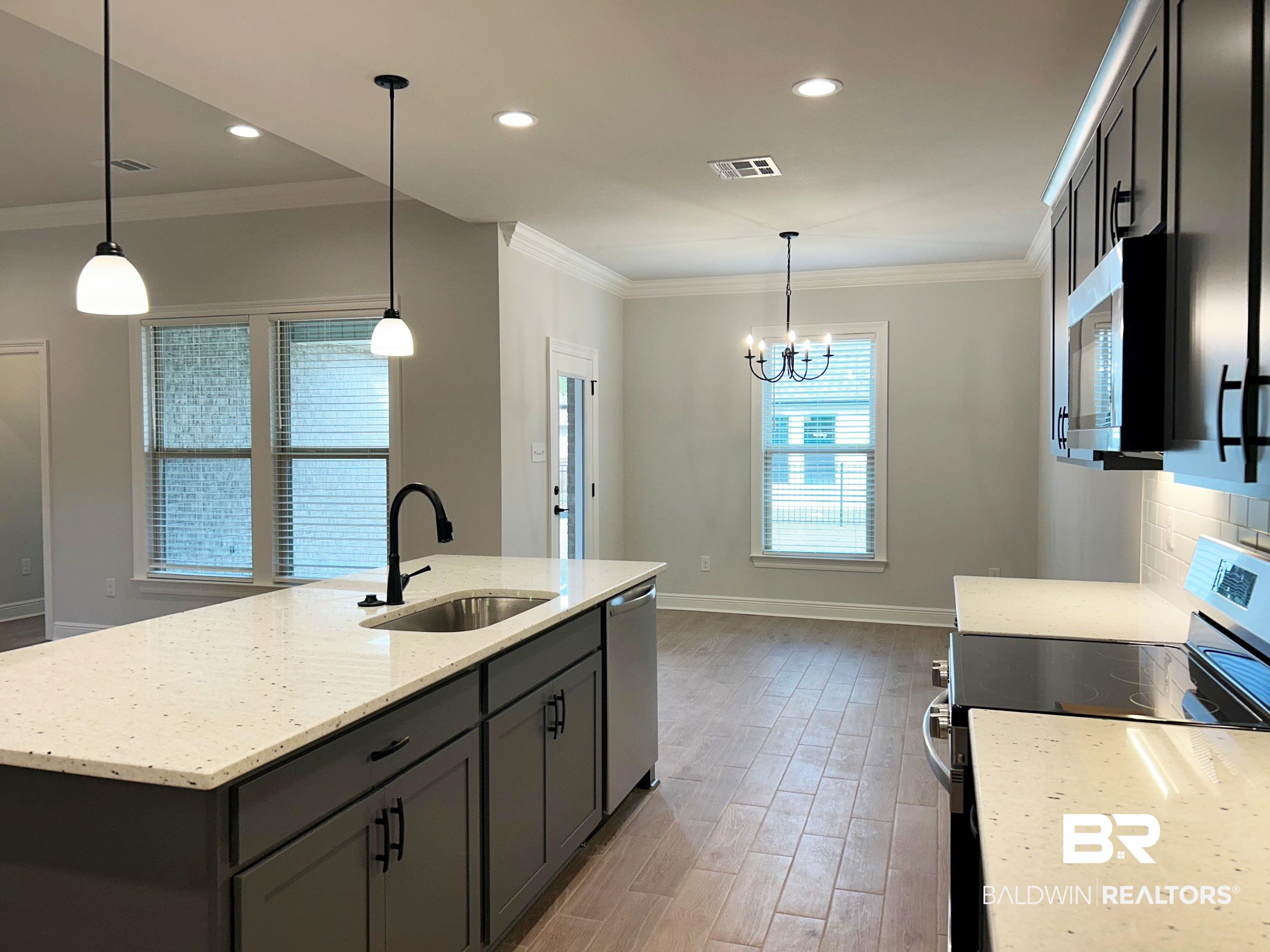 869 Sumter Loop Foley, AL 36535 - Photo 5 of 24 Kitchen with stainless steel appliances, ornamental molding, light stone counters, pendant lighting, and light wood-style flooring