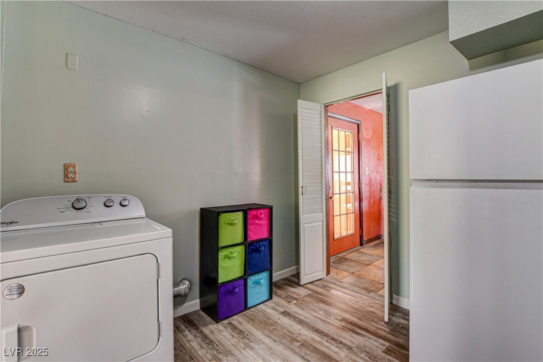 239 West Basic Road Henderson, NV 89015 - Photo 35 of 43 Clothes washing area with washer / clothes dryer, light wood-type flooring, laundry area, and baseboards