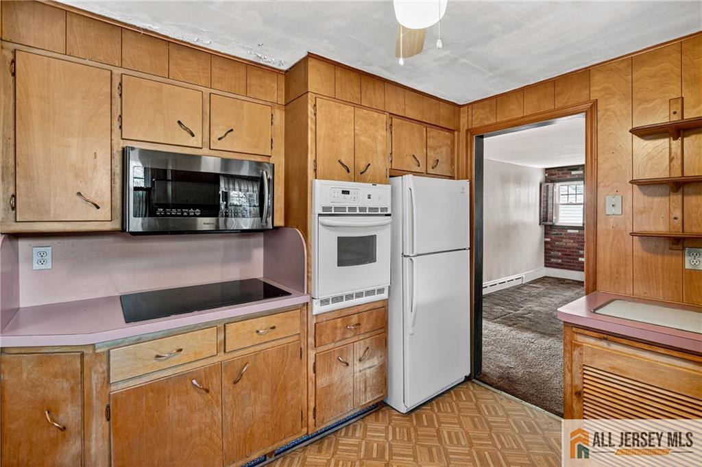 529 4th Street Dunellen, NJ 08812 - Photo 11 of 25 a kitchen with stainless steel appliances granite countertop a refrigerator a microwave oven cabinets and living room view