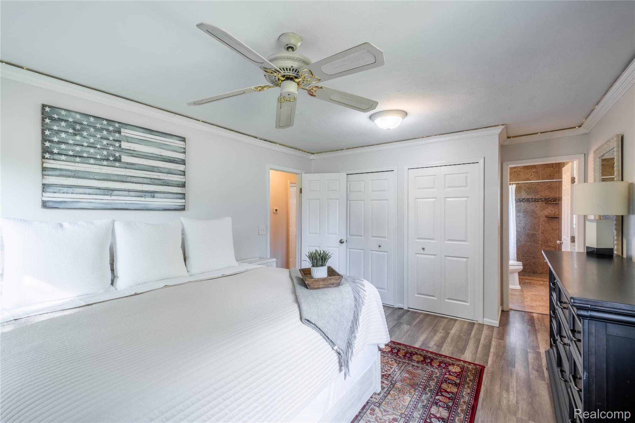 4418 North Gale Road Davison, MI 48423 - Photo 32 of 46 Spacious sleeping area featuring wood-finish flooring, a ceiling fan with integrated lighting, and multiple bi-fold closet doors