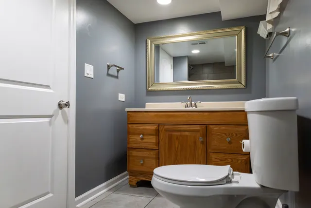 a bathroom with a toilet a sink and mirror