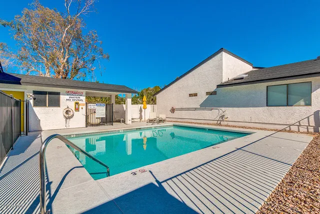 a view of a house with pool and chairs
