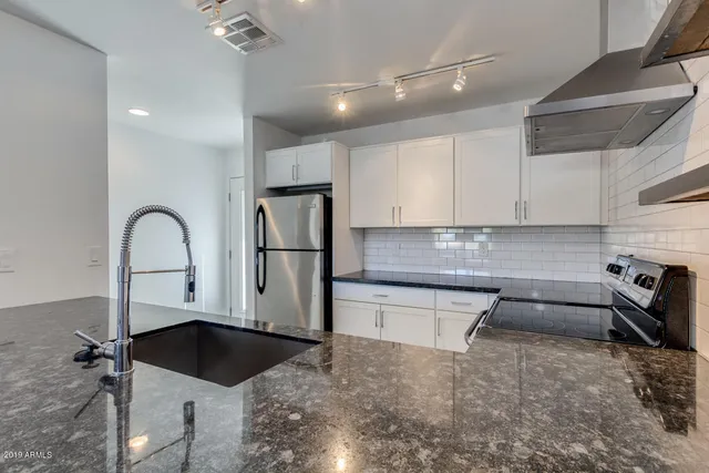 a kitchen with a sink a refrigerator and cabinets
