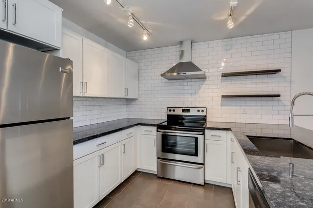a kitchen with stainless steel appliances a stove a sink and a refrigerator
