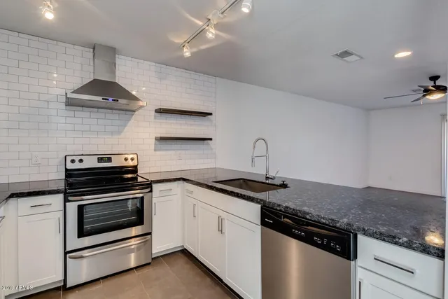 a kitchen with stainless steel appliances granite countertop a stove and a sink