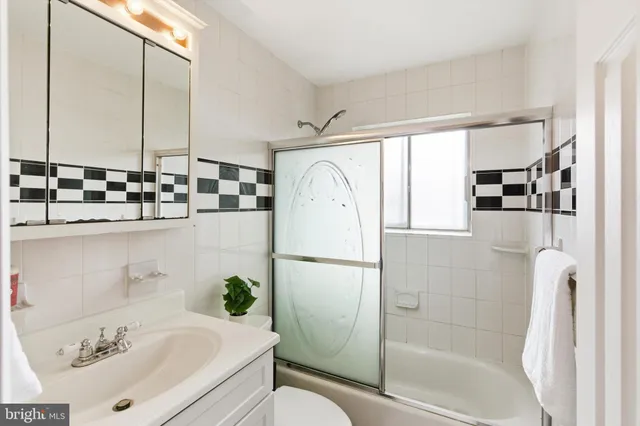 a white bath tub sitting next to a white sink and vanity