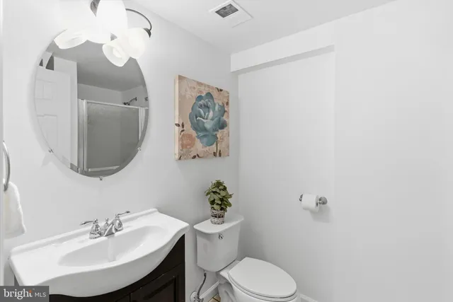 a bathroom with a toilet a sink and mirror