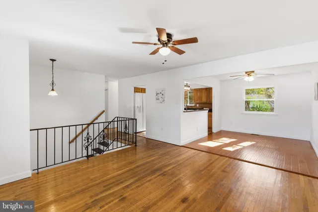 a view of a livingroom with wooden floor and a ceiling fan