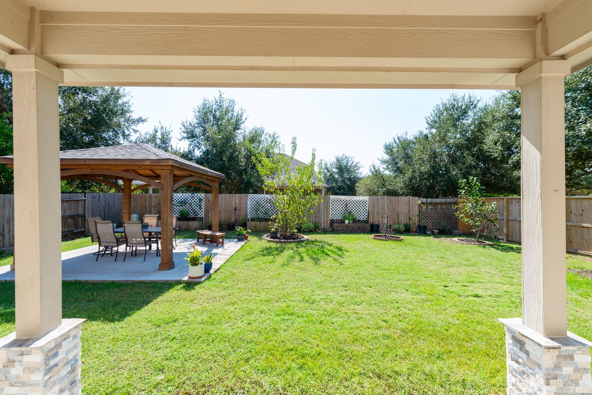 6402 Addlestone Ridge Lane Katy, TX 77494 - Photo 22 of 25 View from the covered patio overlooking the spacious, fully fenced backyard and custom pergola—an ideal setting for outdoor dining, entertaining, or simply relaxing. Enjoy the generous green space without the work, as professional lawn maintenance is included in the rent.