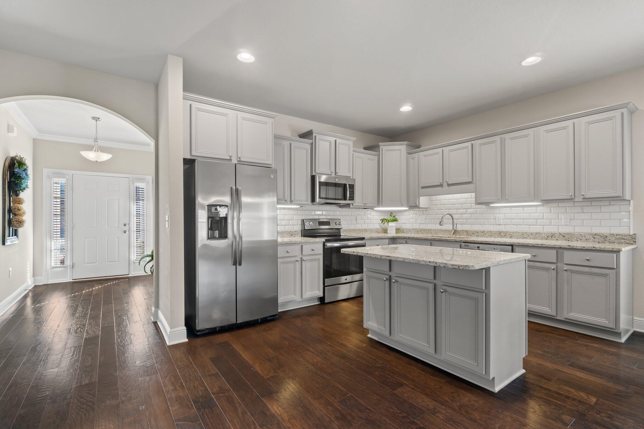 262 Pin Oak Loop Santa Rosa Beach, FL 32459 - Photo 1 of 29 a kitchen with stainless steel appliances granite countertop a refrigerator a sink dishwasher a stove and white cabinets with wooden floor