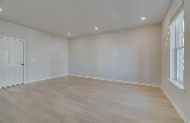 wooden floor in an empty room with a window