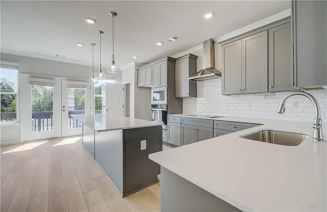 a kitchen with stainless steel appliances granite countertop a sink a stove and a wooden floors