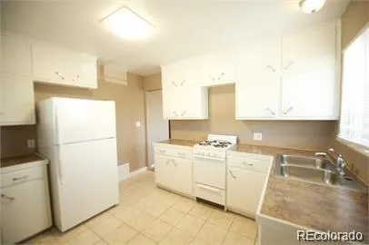 a kitchen with granite countertop white cabinets and white appliances