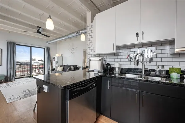a kitchen with stainless steel appliances granite countertop a sink a stove and cabinets