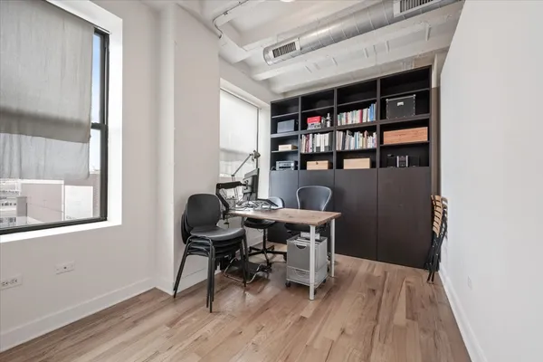 a view of a workspace with furniture and wooden floor
