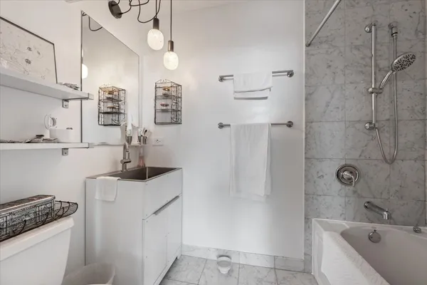 a bathroom with a granite countertop sink a toilet and shower