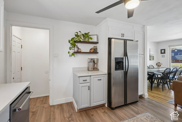 7391 Ramanee Drive Midvale, UT 84047 - Photo 10 of 45 Stainless steel refrigerator, white cabinetry, wood-finish flooring, light-colored countertops, and open shelving