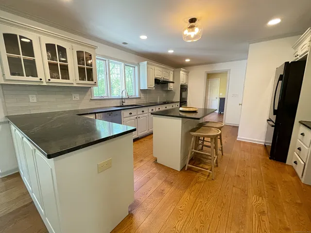 a kitchen with a refrigerator and a stove top oven