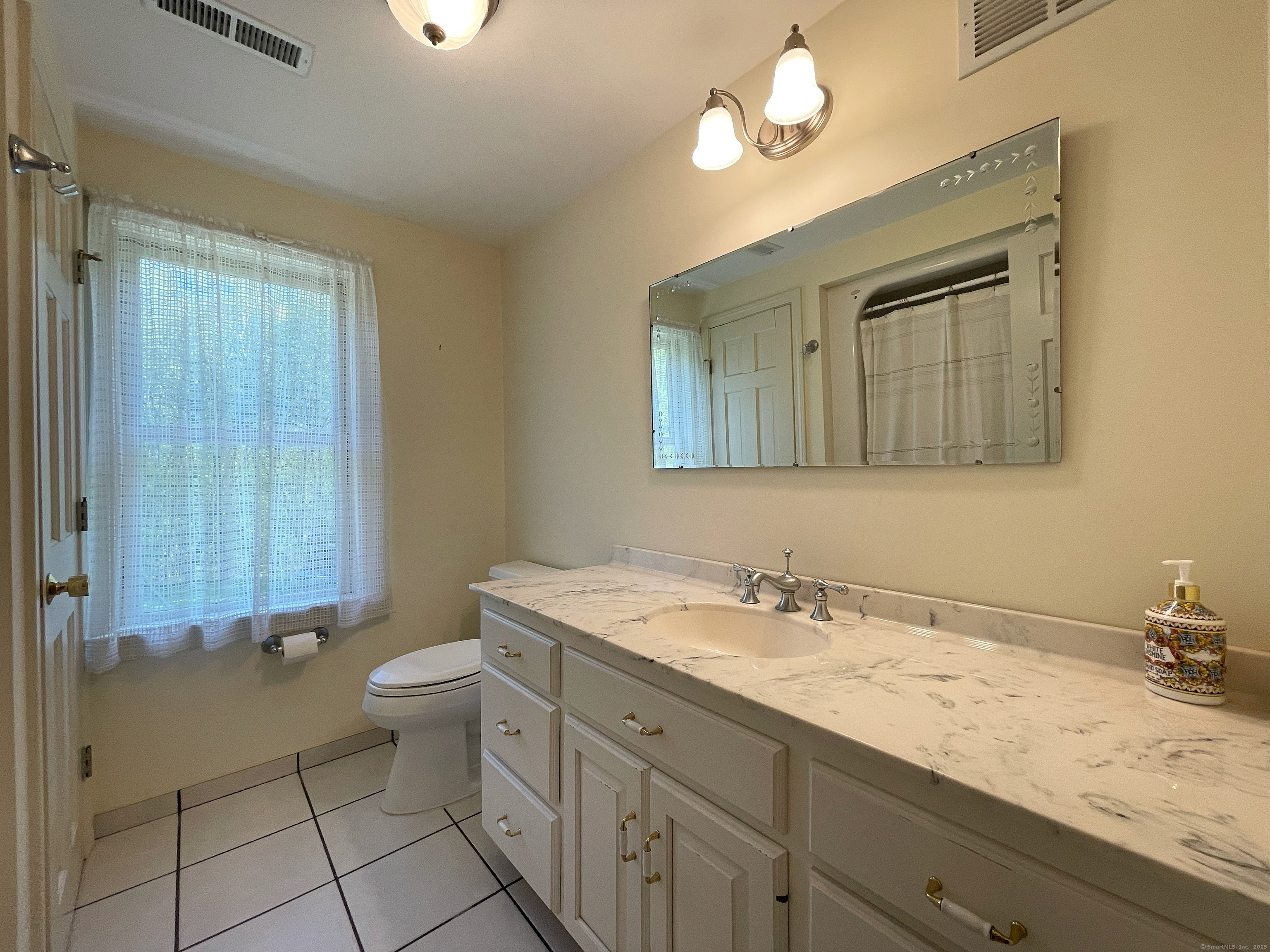 170 Rabbit Hill Road Warren, CT 06777 - Photo 15 of 28 a bathroom with a granite countertop sink a toilet and a mirror