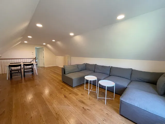 a large bedroom with a bed and wooden floor