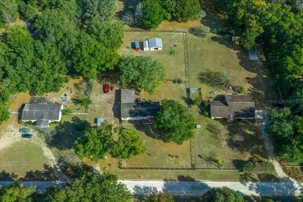 a house view with swimming pool and trees in the background