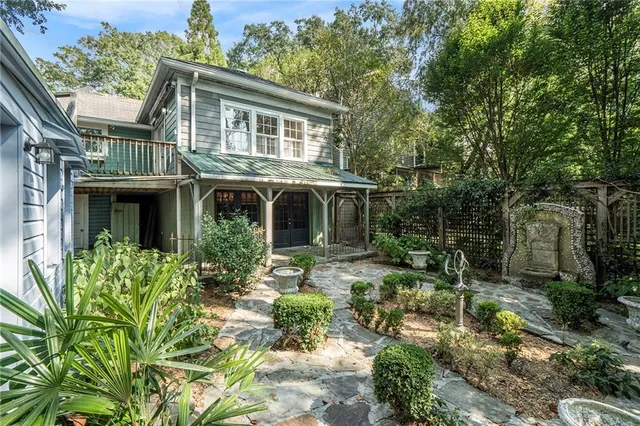 a front view of a house with a yard and potted plants