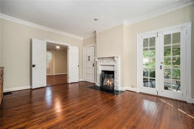 a view of empty room with wooden floor and fireplace