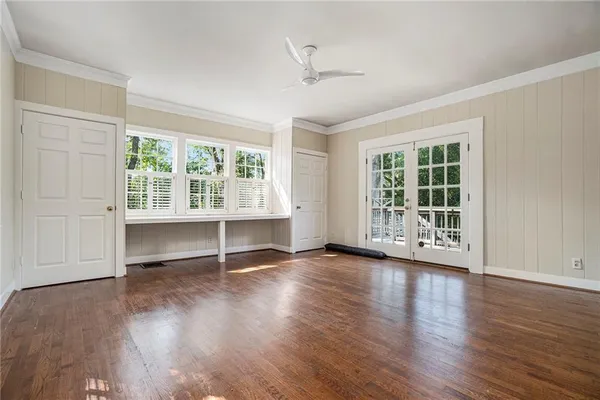 an empty room with wooden floor and windows