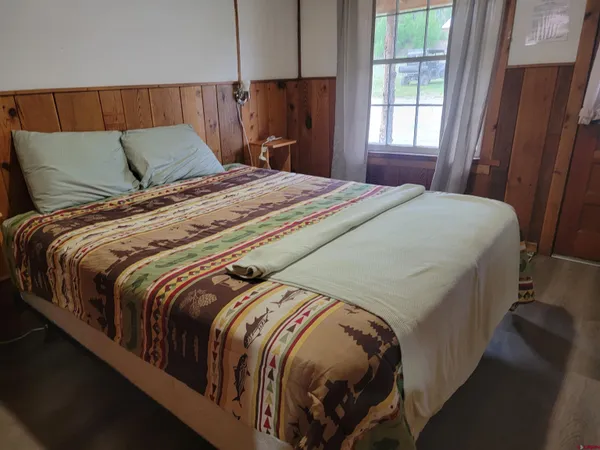 a bed sitting in a bedroom next to a window