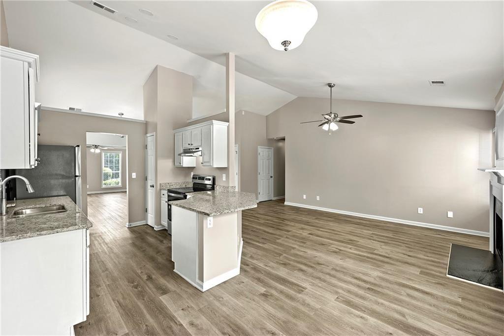 6020 Aderhold Way Alpharetta, GA 30004 - Photo 4 of 16 a large kitchen with granite countertop a large counter top a sink stainless steel appliances and cabinets