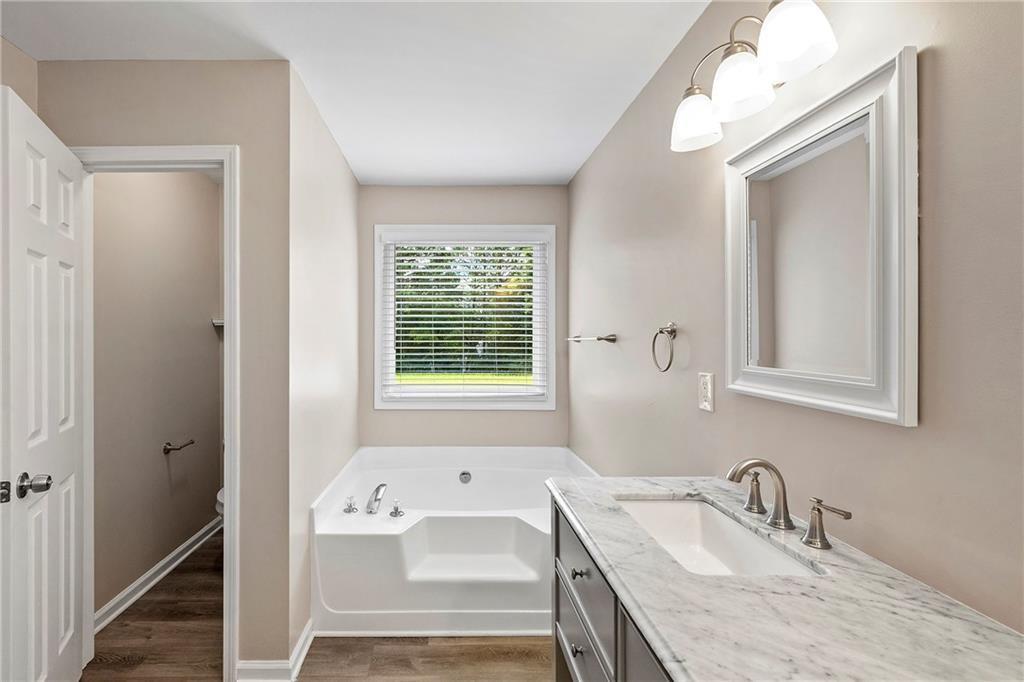 6020 Aderhold Way Alpharetta, GA 30004 - Photo 7 of 16 a bathroom with a granite countertop tub sink and mirror