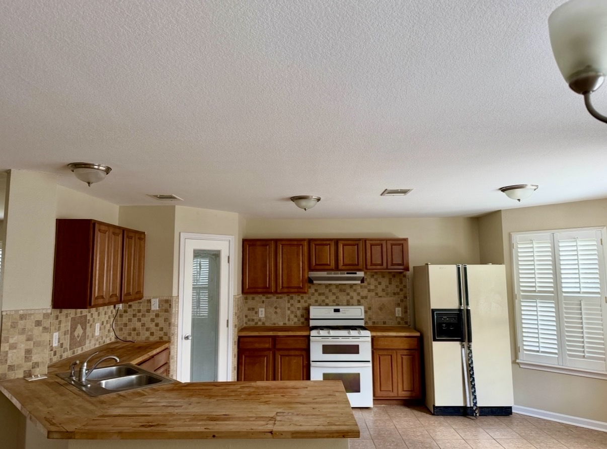 1148 Amberwood Loop Kyle, TX 78640 - Photo 7 of 20 a kitchen with stainless steel appliances granite countertop a refrigerator and stove