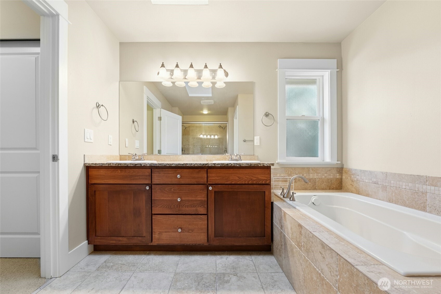 16555 Carlyle Hall Road North Shoreline, WA 98133 - Photo 14 of 27 a bathroom with a granite countertop bathtub a sink and a large mirror