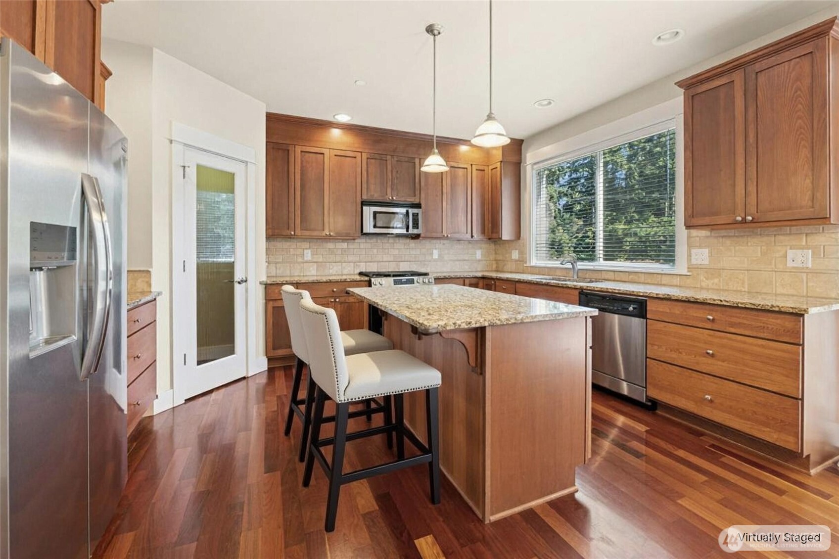 16555 Carlyle Hall Road North Shoreline, WA 98133 - Photo 7 of 27 a kitchen with stainless steel appliances granite countertop a table chairs refrigerator and microwave