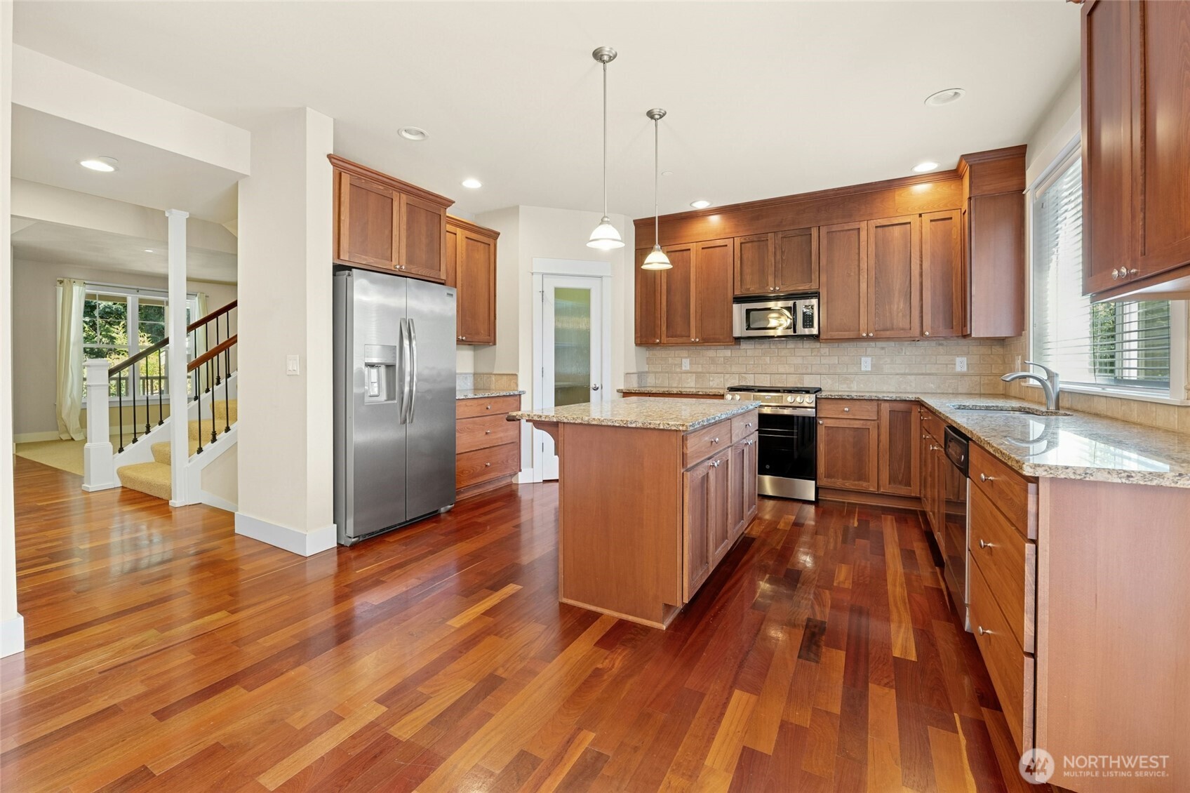 16555 Carlyle Hall Road North Shoreline, WA 98133 - Photo 8 of 27 a kitchen with stainless steel appliances granite countertop a refrigerator a sink dishwasher a stove and white countertops with wooden floor