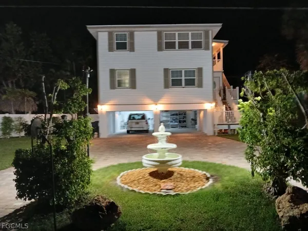 a front view of a house with a yard fire pit and outdoor seating