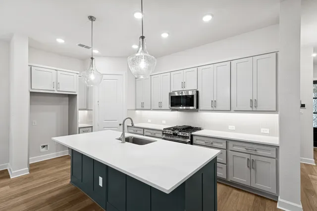 a large kitchen with kitchen island a sink stainless steel appliances and cabinets