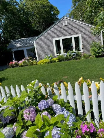a front view of a house with a yard and outdoor seating