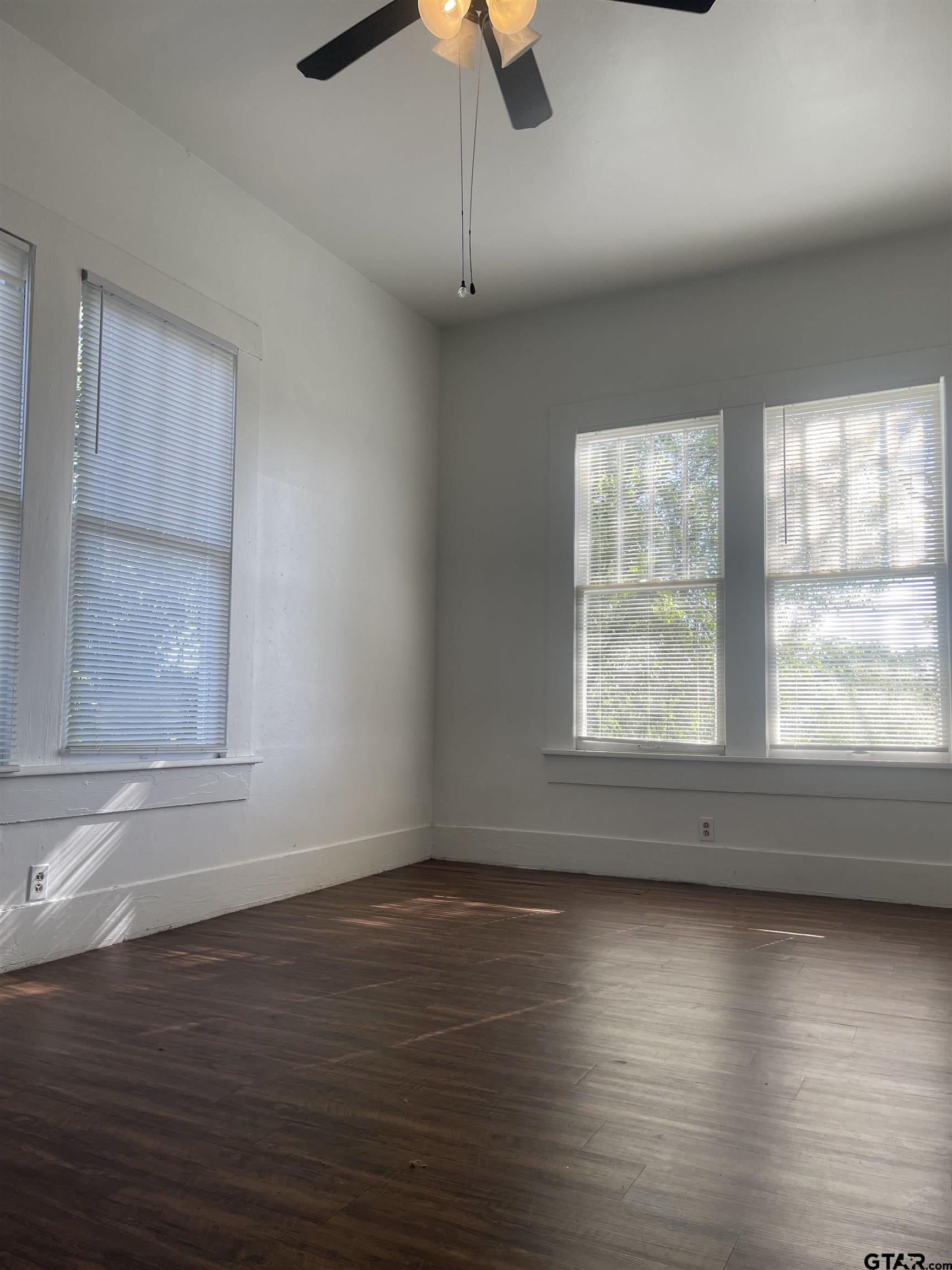 306 South Fenton Avenue Tyler, TX 75702 - Photo 3 of 11 an empty room with wooden floor and windows