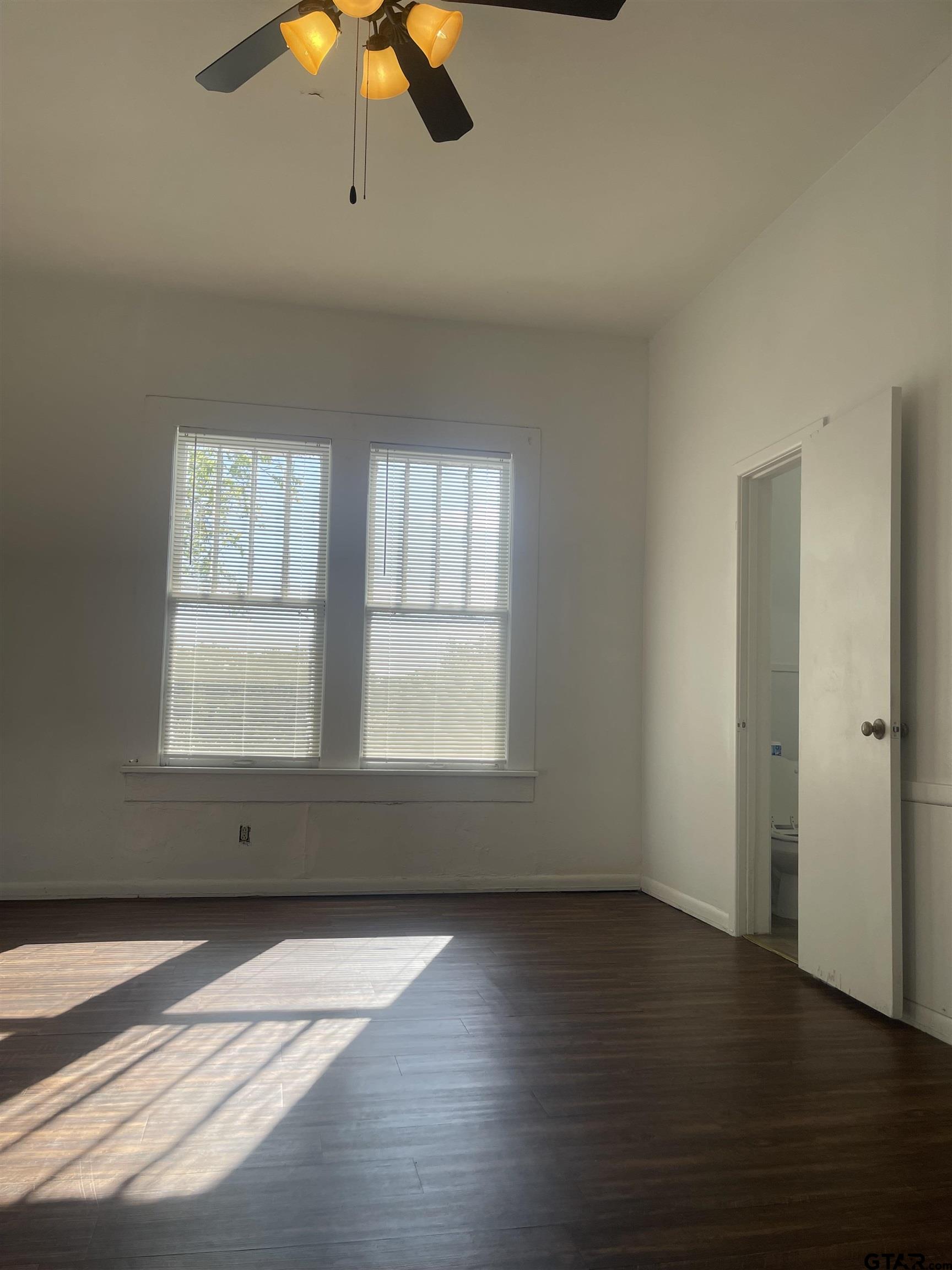 306 South Fenton Avenue Tyler, TX 75702 - Photo 6 of 11 an empty room with wooden floor and windows