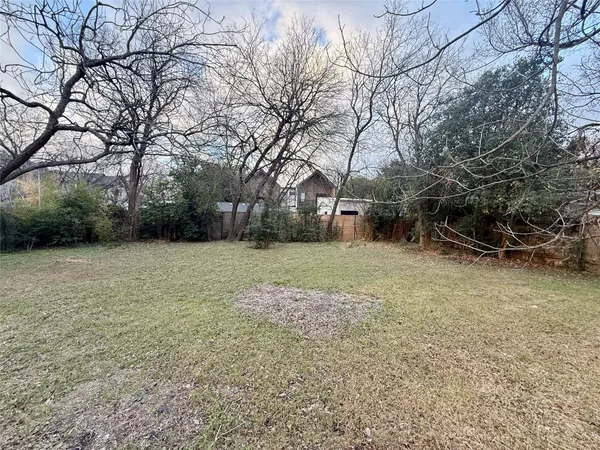 a view of a backyard with large trees