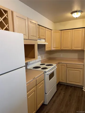a kitchen with cabinets appliances and wooden floor