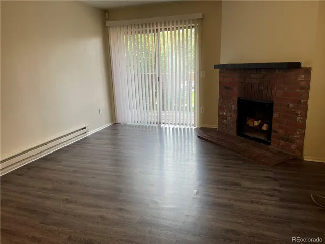 an empty room with wooden floor and fireplace