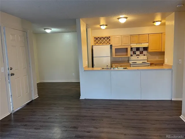 a view of a refrigerator in kitchen and wooden floor