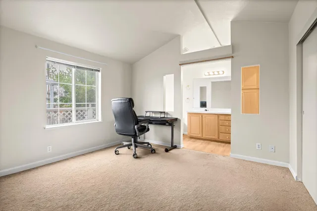 a view of a workspace with furniture and a window